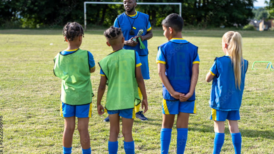 A coach talking to young football players